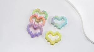 Macro detail of acrylic pixel heart beads with iridescent finish for DIY jewelry