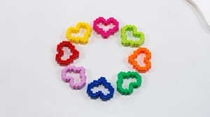 Detail of 8 colorful 16-bit pixel heart beads with threading holes for DIY jewelry