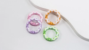 Close-up of colorful round spring ring clasps with wavy texture and polka dot pattern