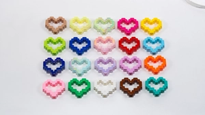 Flat lay of colorful acrylic pixel heart beads with hollow centers for DIY jewelry making