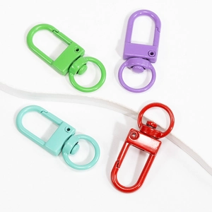 Lot de quatre mousquetons rotatifs en métal laqué coloré en vert violet bleu et rouge