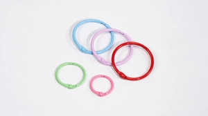 Détail d'anneaux de reliure en métal peint de différentes tailles aux couleurs vives
