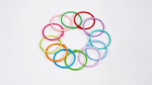 Gros plan de douze anneaux de reliure en métal coloré disposés en cercle arc-en-ciel