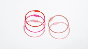 Close-up of colored wire keychains with barrel connectors showing various pink and red tones