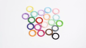 Macro detail of colorful round alloy spring ring clasps in various vibrant painted finishes