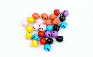 Primer plano de cascabeles de metal de colores para manualidades y joyería DIY