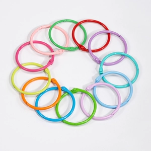Lot d'anneaux de reliure en métal coloré sur un fond blanc propre et lumineux