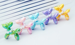 Detail of five colorful iridescent resin balloon dog charms with pearl collar for DIY crafts