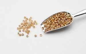 Detailansicht der kleinen goldenen Quetschperlen aus Metall für DIY-Schmuck und Bastelarbeiten