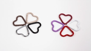Macro detail of heart shaped carabiner clips in multiple colors with spring gate design