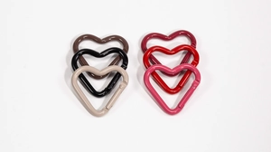 Macro detail of heart-shaped spring ring clasps in six different vibrant lacquer colors