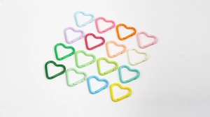 Macro shot of colorful heart-shaped alloy spring rings with matte paint finish for DIY