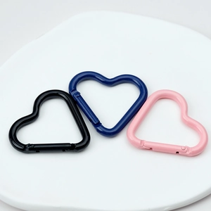 Three colorful heart-shaped spring ring carabiners in black, navy blue, and pink alloy