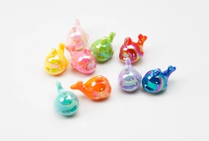 Macro view of colorful pearlescent resin whale pendants for DIY keychain accessories