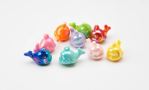 Detailed view of colorful luminous whale pendants with hanging loops for DIY crafts