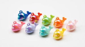 Detailed view of colorful iridescent whale charms for DIY jewelry and phone accessories