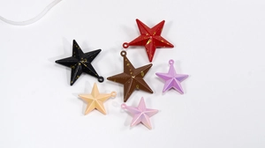 Close-up of colorful star shaped DIY charms for jewelry making with hanging holes
