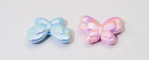 Detail van iriserende vlinderbedeltjes in roze en blauw voor doe-het-zelf sieraden