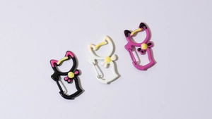 Detail showing cat-shaped metal spring rings in black, white, and rose red painted finish