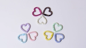 Vista macro di moschettoni colorati a forma di cuore con strass scintillanti per il fai-da-te