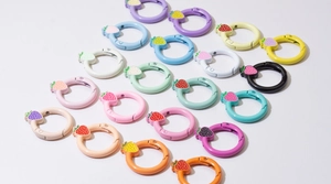 Close-up of colorful round spring ring buckles with cute painted strawberry charms