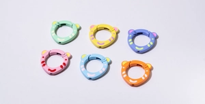 Detailed view of colorful bear-shaped spring rings with polka dots for DIY keychains