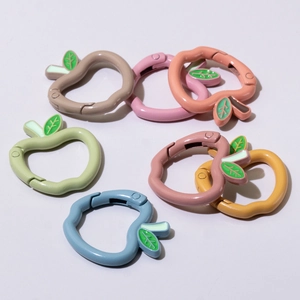 Moschettoni in metallo a forma di mela con dettaglio foglia in colori vivaci macaron
