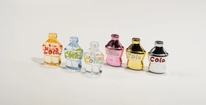 Dettaglio di sei perline colorate a forma di bottiglia di cola per la creazione di gioielli