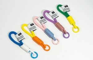 Close-up of five colorful hand-woven lanyards with spring rings and fabric labels