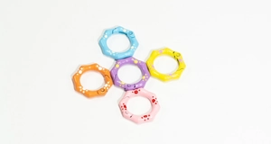 Detail van gekleurde springringen met golfkartelrand en polkadots voor DIY-accessoires