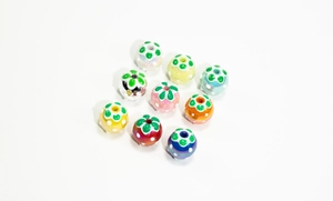 Macro view of colorful strawberry shaped ceramic beads with hand-painted dots for DIY jewelry