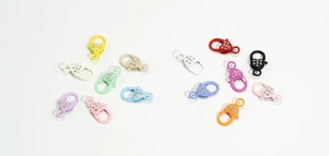 Dettaglio di chiusure a moschettone a forma di cuore con strass in 13 colori vari