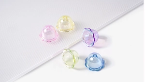 Detailansicht bunter, lichtdurchlässiger Perlen in Blumenform für DIY-Schmuck