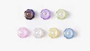 Detailansicht von sieben bunten lichtdurchlässigen Harzperlen in Blumenform für DIY Schmuck
