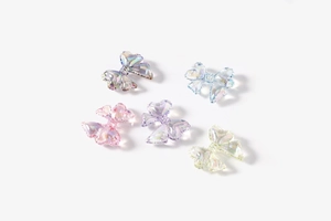 Detailed view of 3D iridescent bow-shaped resin beads for DIY jewelry and accessories