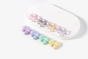 Detail of colorful bow-shaped resin beads with pearlescent finish for DIY jewelry making