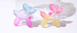 Macro detail of gradient resin balloon dog charms with matte finish and colorful neck beads