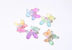 Top view of five colorful frosted resin balloon dog pendants for DIY jewelry and keychain making