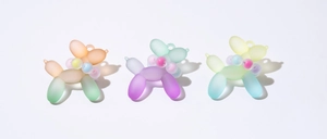 Macro detail of gradient frosted resin balloon dog charms with colorful bead accents