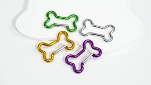 Macro shot of 4 colorful bone-shaped aluminum carabiners with silver spring gate clips
