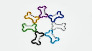 Macro detail of colorful bone-shaped aluminum carabiner hooks with spring gate locks