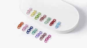 Macro shot of 14 colorful alloy chain links for DIY jewelry making on white background