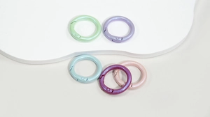 Close-up of five colorful pearlescent spring O-rings for DIY keychains and bag accessories