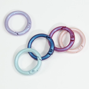 Five colorful pearlescent round spring rings in purple blue pink and green for DIY crafts