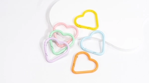 Close-up of heart-shaped macaron spring carabiners in various pastel candy colors