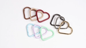 Macro view of colorful heart-shaped carabiners in matte and metallic finishes