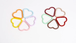 Macro shot of colorful heart-shaped carabiners in pastel and vintage tones for DIY