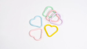 Macro shot of colorful heart-shaped carabiners in macaron pastel tones for DIY accessories