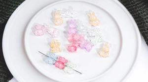 Macro detail of cracked acrylic beads in bear and rabbit shapes for DIY jewelry making
