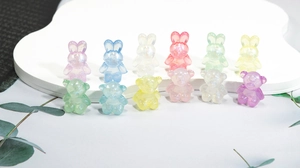 Close-up of glittery acrylic rabbit and bear beads for DIY jewelry making